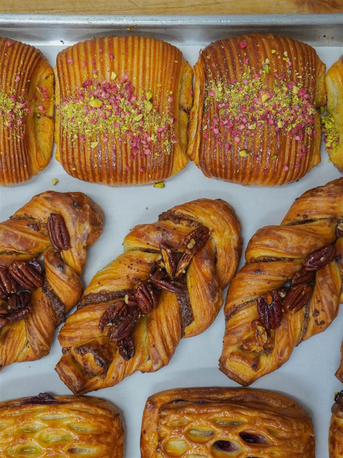 Cherry Almond Danish, Pecan Maple Plait and Pistachio Raspberry Pain Suisse on a tray
