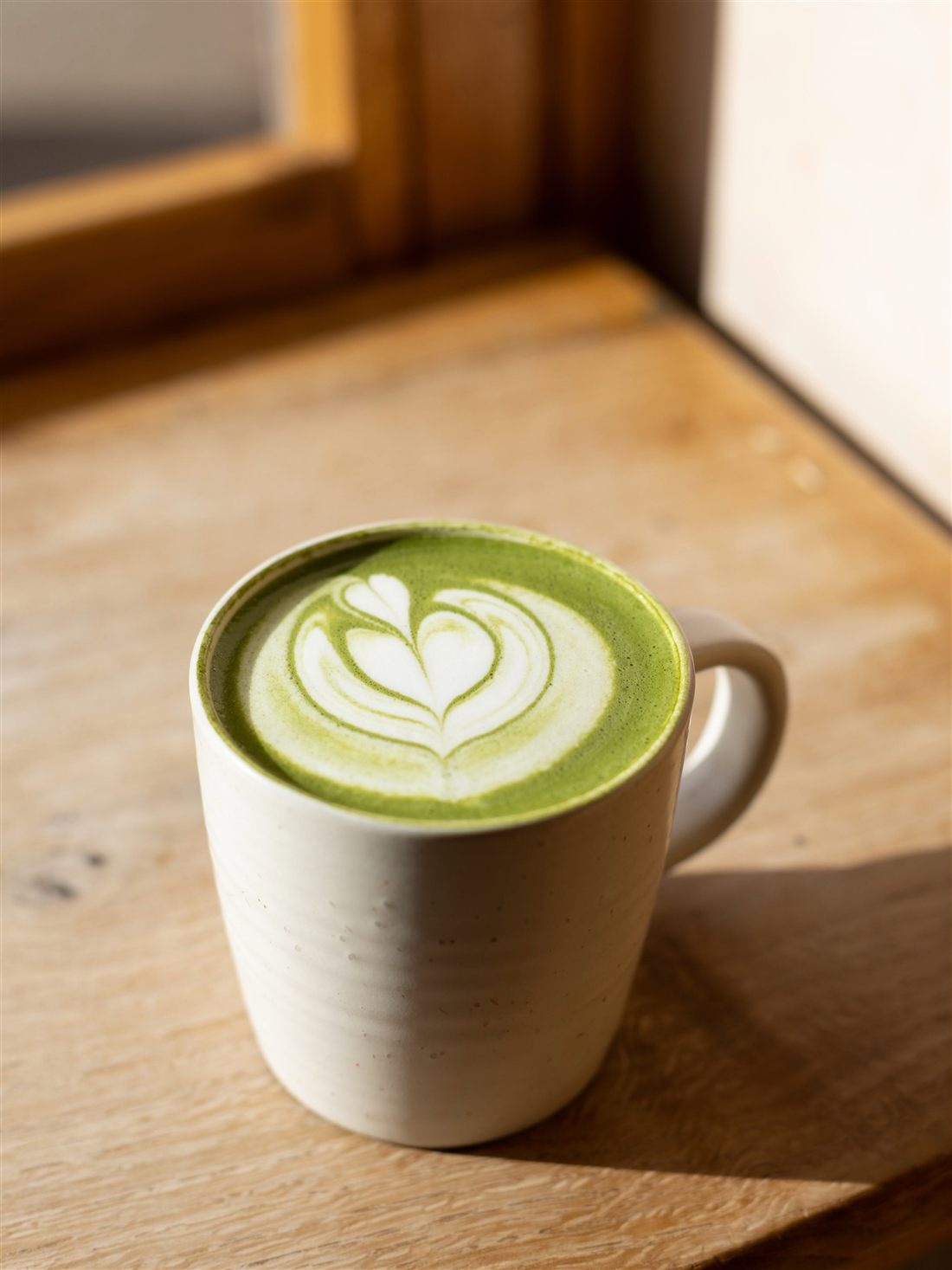 A matcha latte on a wooden sill